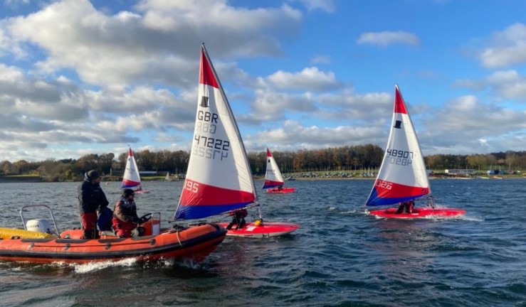 Topper sailors taking part in an RYA Regional Training Group on-the-water session with coaches alongside in a RIB.