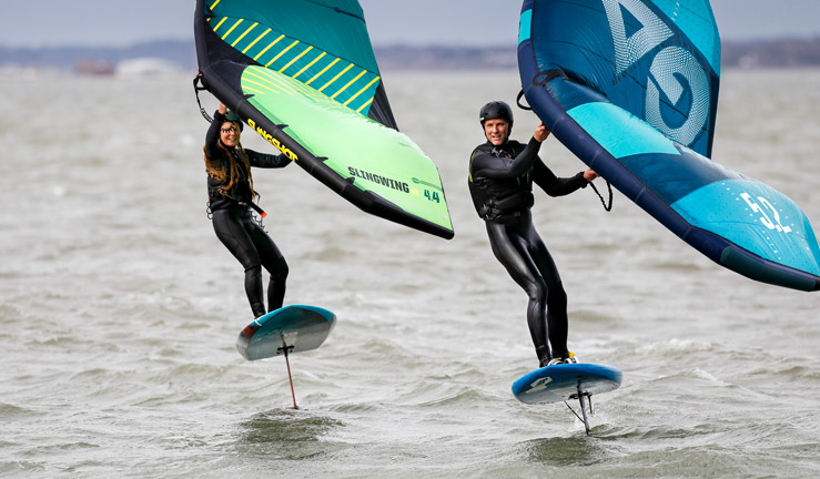 Man and woman wingfoiling