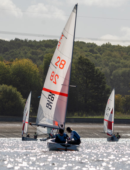 action shot of two young sailor taking part in dinghy race on the open water