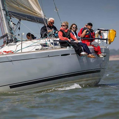 posed shot of 5 sailor sitting of the front a large while out at sea