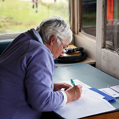 candid shot of volunteer writing in ledger