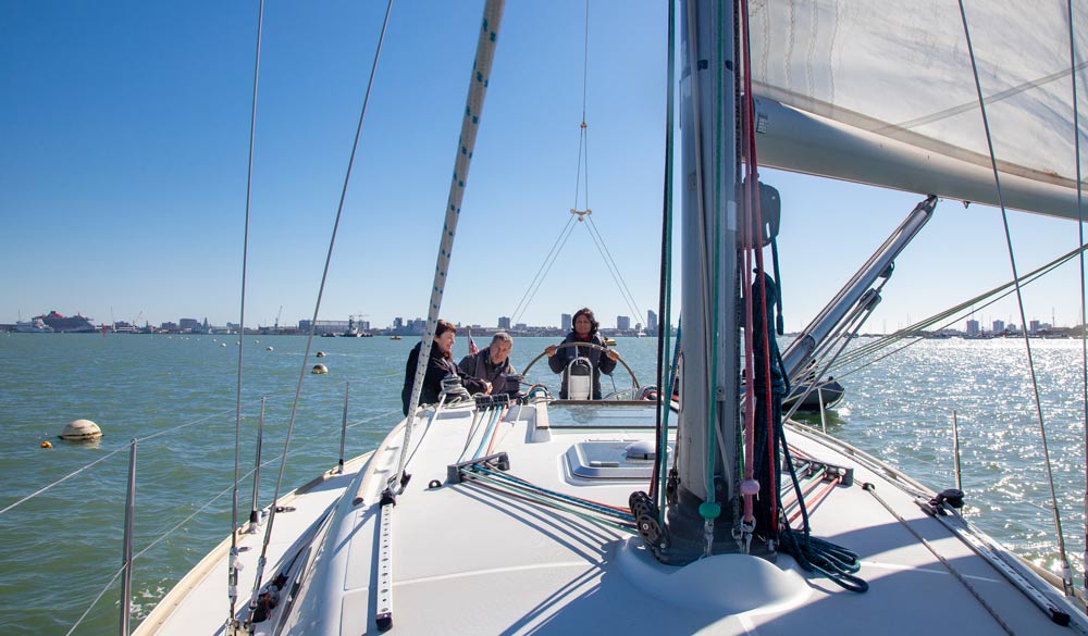 wide shot of boat with 3 sailors