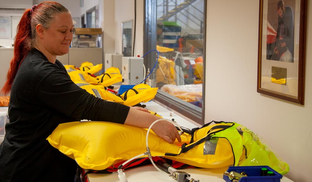 Woman carrying out lifejacket servicing 